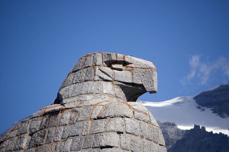 A statue of an eagle, head details, mountains in backgroundの写真素材