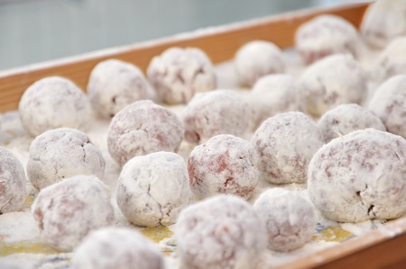 Meat ball in the flour on a tray ready to be cookedの写真素材