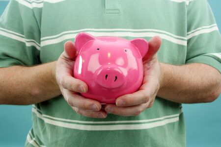 Man Holding Piggy Bank With His Savingsの写真素材