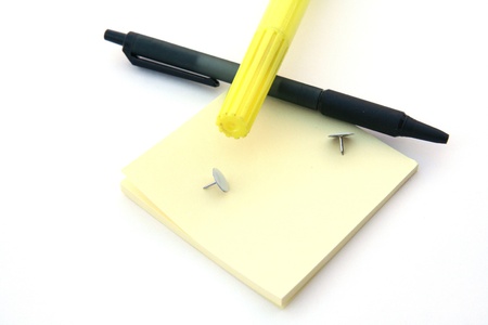 Post it notes and a pen sitting on a white background