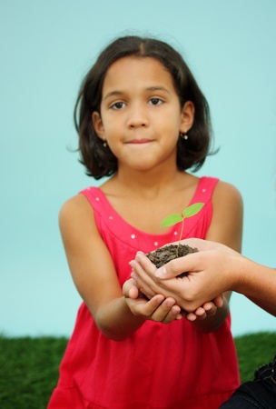 Woman Holding A New Plant In Dirtの写真素材