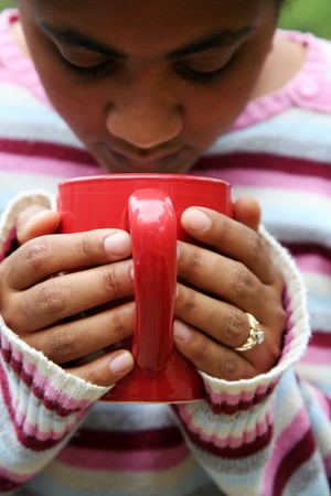 Woman drinking a hot cup of coffeeの写真素材
