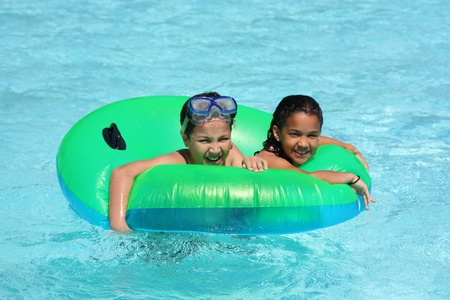 Girl and Boy in a pool floating on a tube