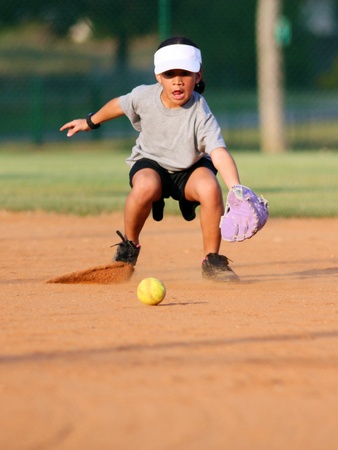 Young girl playing in a game of softballの写真素材