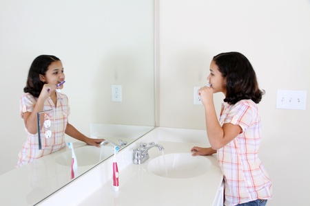 Person looking into a mirror brushing their teethの写真素材
