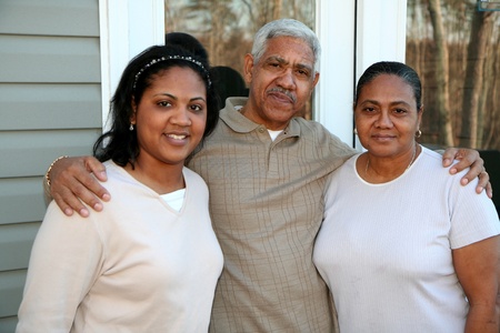 Minority family standing outside their new home