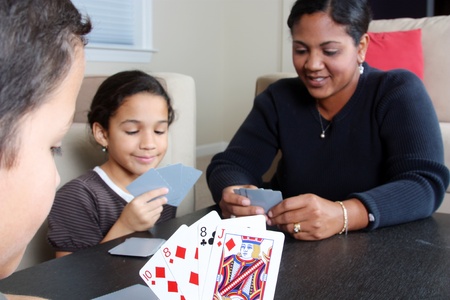 Family playing cards together around the tableの写真素材