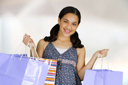 Teen girl shopping with bags on white backgroundの写真素材