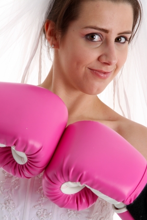 Woman in a wedding dress with boxing glovesの写真素材