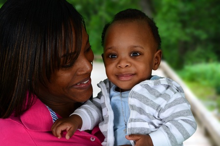 Young mom standing outside with her babyの写真素材