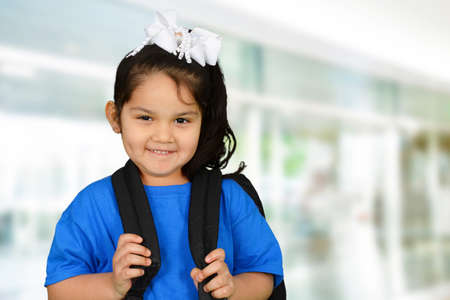 Little schoolgirl in blue t-shirt going to school