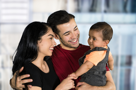 Happy young couple who are standing with their son
