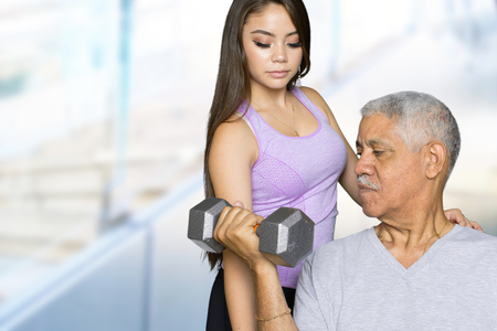 Elderly man working out with a personal trainerの写真素材