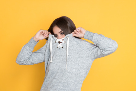 Teen hispanic girl posing on a yellow backgroundの写真素材