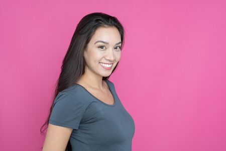 Young happy woman posing on a pink background