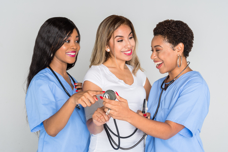 Two african american nurses working with a patient at the hospitalの写真素材