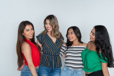 Group of four teenage hispanic female friends smiling and laughingの写真素材