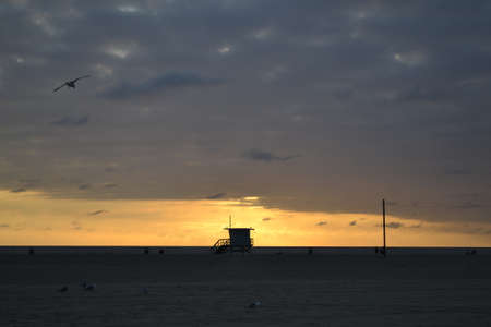 Sunset by Venice Beach with a lifeguard cabin in front of the sunの写真素材
