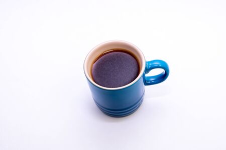 Blue porcelain cup filled with coffeeの写真素材