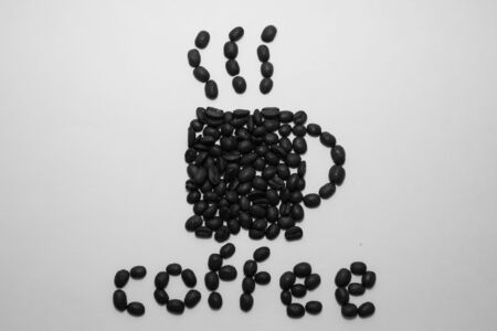 Cup of coffee shape and the word coffee created with coffee beans over a white backgroundの写真素材