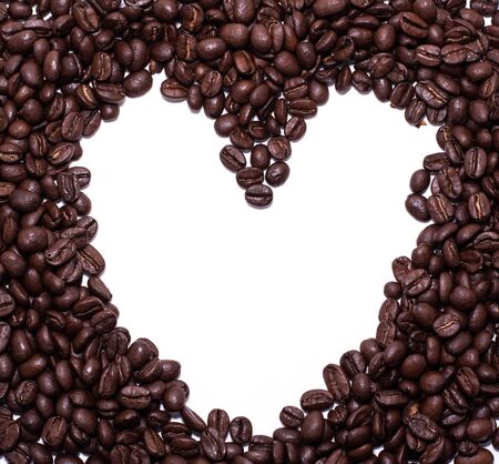 Heart frame formed by coffee beans over a white backgroundの写真素材