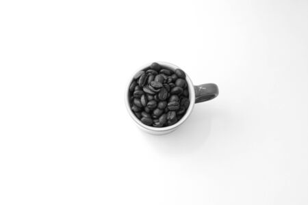 Coffee beans inside a mug isolated over white backgroundの写真素材