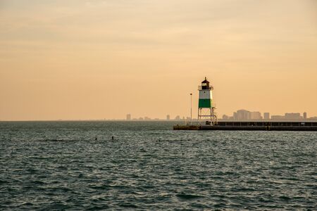 Views of a lighthouse at sunset in the Michigan lakeの写真素材