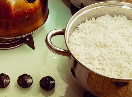 Photograph of a pan with boiled rice on cooktop.の写真素材