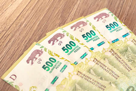 Pesos banknotesof argetina's currency, the Argentine peso, on a wooden desk. Photo for...