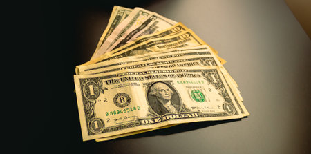 A lot of one hundred dollar bills lies on a dark background.の写真素材