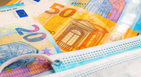 Euro banknotes and medical mask close-up. Coronavirus conceptの写真素材