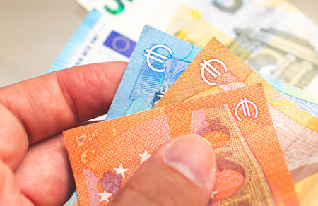 Euro banknotes in the hands of a man close-up.の写真素材