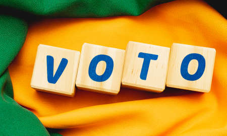 VOTE word made with wood building blocks on yellow fabric background.の写真素材
