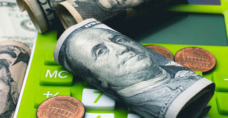 Dollars and coins on the background of the calculator. Business conceptの写真素材