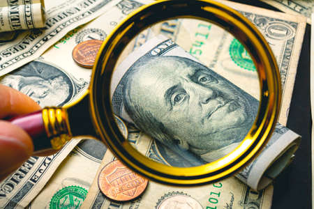 Money and magnifying glass. The concept of financial analysis and investment.の写真素材