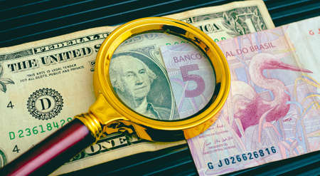 Dollars and magnifying glass on the table. Business concept