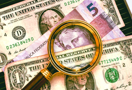 Magnifying glass and dollar banknotes. Business and finance concept.