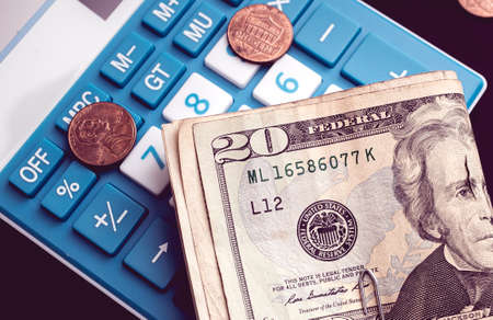 Calculator with dollar bills and coins. Concept of business and financeの写真素材