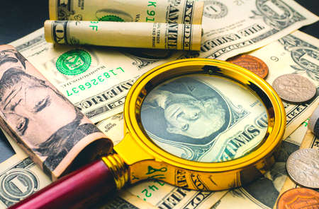 Money and magnifying glass. Magnifying glass on dollar banknotes.の写真素材