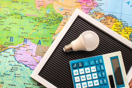 Light bulb, calculator and map. Concept of saving money for the future