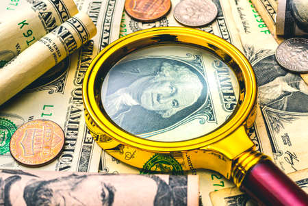 Magnifying glass and dollar banknotes on the background of the dollar.の写真素材