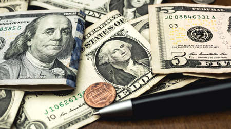 dollars and a pen on a wooden table, business backgroundの写真素材
