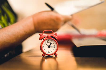 Red alarm clock on the table in the office. The concept of time management.の写真素材