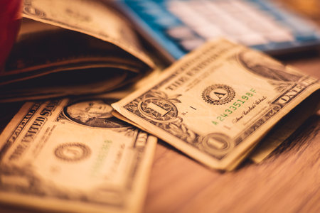 US dollar banknotes on a wooden surface. A blue calculator in the image composition. Economy,...