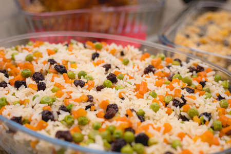 Close up of a bowl of mixed rice with peas and carrots.の写真素材