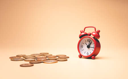 Alarm clock and coins on color background. Time is money conceptの写真素材