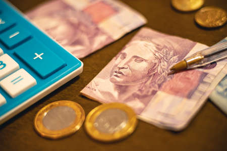 calculator, banknotes and coins on a dark background.の写真素材
