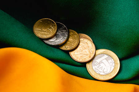 Coins of various countries on the background of a flag.の写真素材
