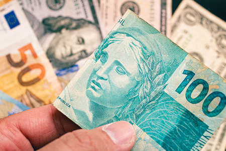 Close-up of one hundred dollar bill in the hands of a manの写真素材