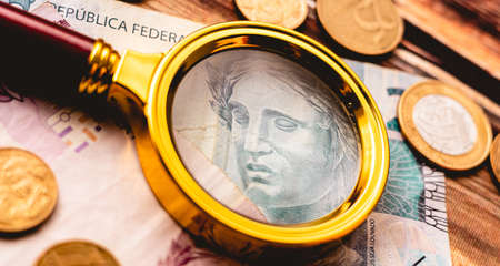 Close-up of a magnifying glass on the background of banknotes.の写真素材